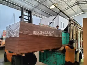Distributor container flooring plywood Indonesia sedang memuat satu bundle triplek kontainer 28mm full kruing ke atas truk armada pengiriman.
