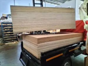 Stok tumpukan plywood veneer mindi di atas armada pengiriman, siap didistribusikan ke pabrik mebel dan proyek interior.