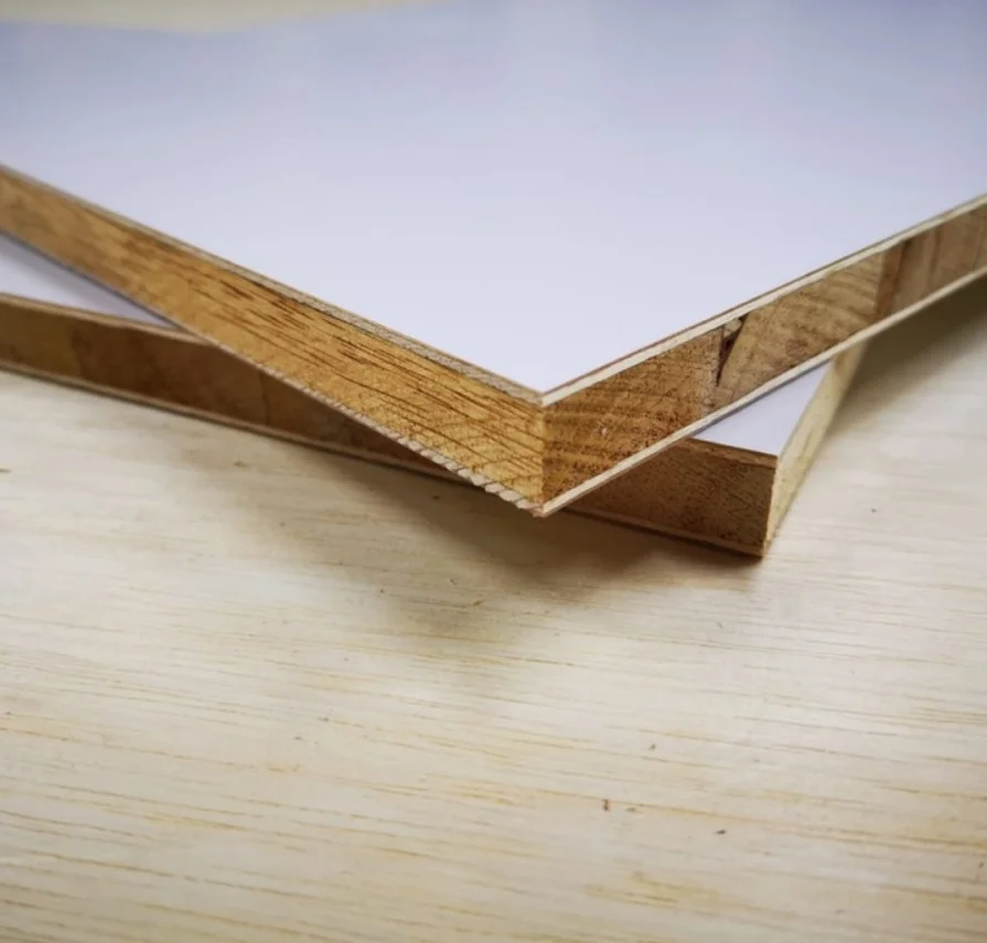 Penampang potong lembaran blockboard melamin putih dengan struktur inti kayu solid untuk bahan pembuatan furnitur interior.