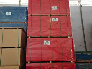 Tumpukan stok grosir Plywood Phenolic Film Indoho yang siap kirim, dibungkus rapi dengan label SVLK Indonesia. Menjamin triplek legal dan berkualitas untuk proyek konstruksi.